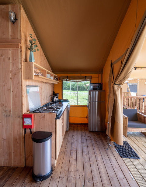 Interior of SunLodge Taiga safari tent at Camping Terme Catez, Slovenia, featuring kitchen and wood decor.