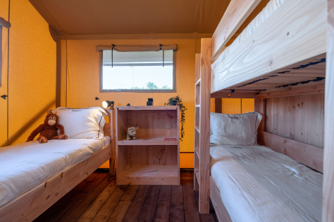 Binnenzicht van de SunLodge Taiga safaritent op Camping Terme Catez, Slovenië, met stapelbed en eenpersoonsbed.