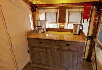 Angolo cucina nella tenda safari SunLodge Jungle con macchina da caffè e bollitore al Camping Vilanova Park in Spagna.