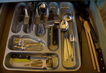 Open cutlery drawer with utensils inside a safari tent at SunLodge Jungle, Camping Vilanova Park, Spain.