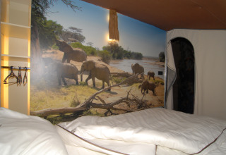 Interior of the SunLodge Jungle safari tent at Camping Vilanova Park in Spain, featuring an elephant mural.