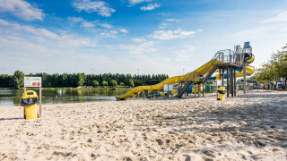 Playa con tobogán amarillo junto al lago en Vakantiepark Klein Strand, parque vacacional en Flandes Occidental, Bélgica.