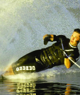 Persona practicando esquí acuático en un lago, creando una gran estela en Klein Strand, Bélgica.