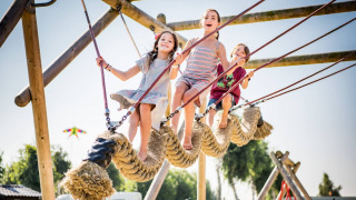 Niños juegan en una gran estructura de cuerdas en Vakantiepark Klein Strand, West Flandes, Bélgica.