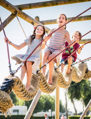 Niños juegan en una gran estructura de cuerdas en Vakantiepark Klein Strand, West Flandes, Bélgica.