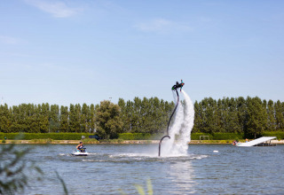 Person schwebt mit einem Wasser-Jetpack im See im Vakantiepark Klein Strand, Westflandern, Belgien