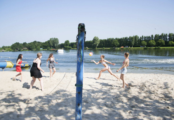 Groep mensen speelt beachvolley aan het strand van Vakantiepark Klein Strand, West-Vlaanderen, België.