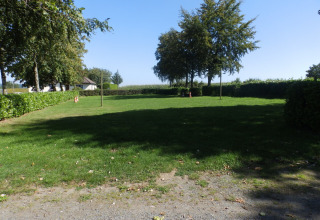 Grønt område med træer og hække på Camping Um Bierg, en ferielejr i Diekirch, Luxembourg.