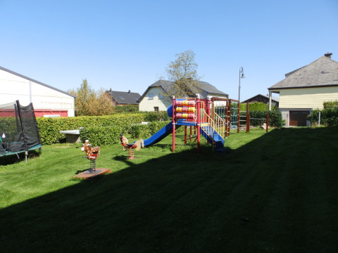Spielplatz mit Rutsche, Trampolin und Schaukeln bei Sonnenschein im Camping Um Bierg, Diekirch, Luxemburg.