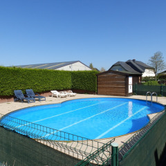 Outdoor swimming pool with sun loungers and playground at Camping Um Bierg holiday park in Diekirch, Luxembourg.