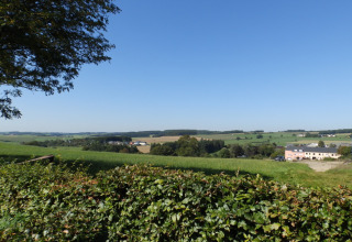 View of the Luxembourg countryside from Camping Um Bierg holiday park in Diekirch under a clear blue sky.