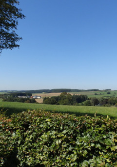 View of the Luxembourg countryside from Camping Um Bierg holiday park in Diekirch under a clear blue sky.