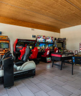 Sala recreativa luminosa en Campeggio Gasparina, Véneto, Italia, con máquinas de juegos y pinball.
