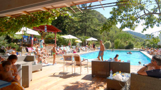 Espace piscine du Camping Delle Rose en Ligurie, Italie, avec des vacanciers profitant du soleil d'été.