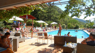 Área de piscina en Camping Delle Rose, Liguria, Italia, donde la gente se relaja y disfruta del paisaje.