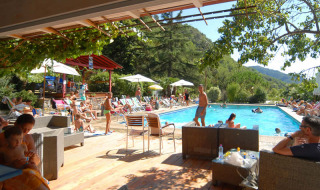 Swimmingpool-område på Camping Delle Rose i Ligurien, Italien, med folk der nyder solen og naturen.