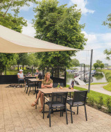 Terraza al aire libre en MarinaPark Bad Nederrijn, con vistas al puerto deportivo y un parque infantil en Gelderland.