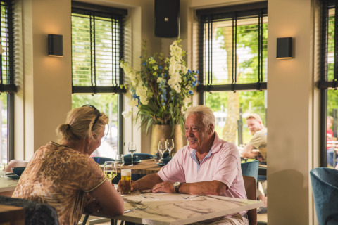 Ouder koppel luncht samen in restaurant bij MarinaPark Bad Nederrijn, Gelderland, Nederland.