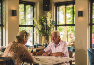 Ældre par nyder frokost sammen på restaurant i MarinaPark Bad Nederrijn, Gelderland, Holland.