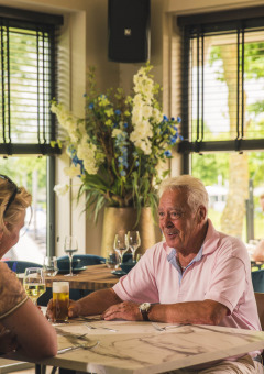 Pareja mayor disfrutando de una comida juntos en un restaurante de MarinaPark Bad Nederrijn, Gelderland, Países Bajos.
