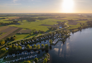 Luftfoto af MarinaPark Bad Nederrijn i Gelderland, Holland, med både, hytter og grønne marker i solskin