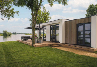 Moderne feriebolig ved søen i MarinaPark Bad Nederrijn, Gelderland, Holland, med træterrasse og grønne områder.