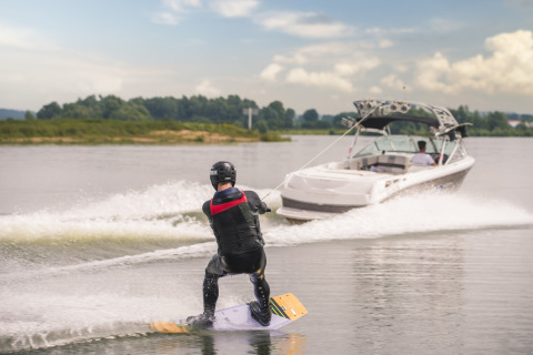 Persoon wakeboard achter speedboot bij MarinaPark Bad Nederrijn, vakantiepark in Gelderland, Nederland.