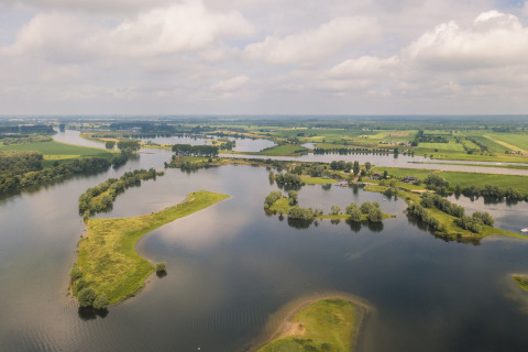 Luftfoto af MarinaPark Bad Nederrijn i Gelderland, Holland, med vand, øer og frodige marker.