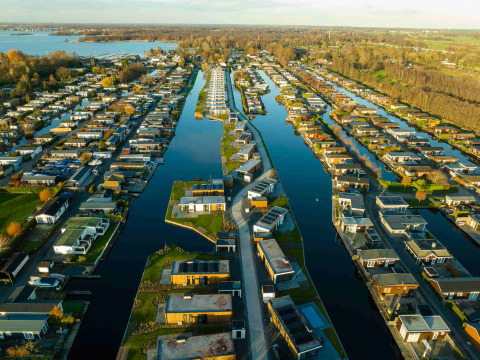Aerial view of MarinaPark Residentie Nieuw Loosdrecht, a holiday park with houses along Dutch canals.
