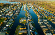 Luftfoto af MarinaPark Residentie Nieuw Loosdrecht, feriepark med huse langs kanaler i Holland.