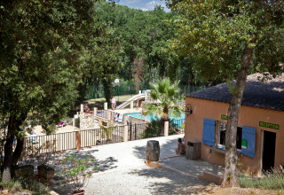 Vista sul villaggio vacanze in Occitania, Francia, con piscina, alberi e reception a Slow Village Provence Occitane.