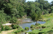 Folk bader og slapper af ved en flod omgivet af grønne træer i Slow Village Provence Occitane, Occitanie.