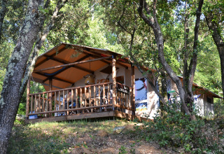 Tenda safari su terrazza in legno immersa tra gli alberi a Slow Village Provence Occitane, Occitania, Francia.