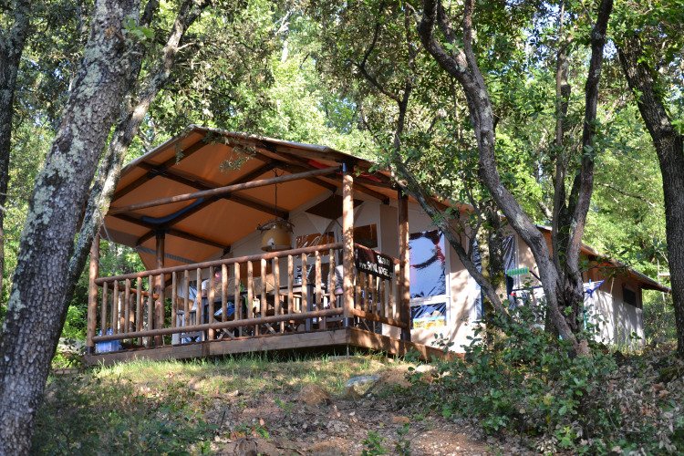 Safari tent on a wooden deck nestled among trees at Slow Village Provence Occitane, Occitanie, France.