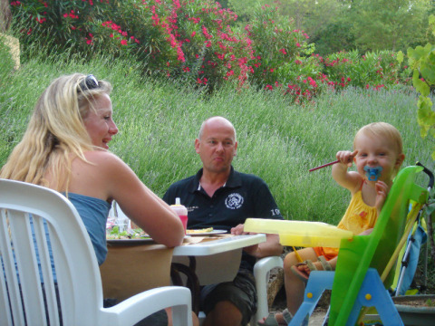 Gezin geniet van een maaltijd in de tuin bij Slow Village Provence Occitane, vakantiedorp in Occitanië, Frankrijk.