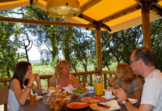 Familie ontbijt samen buiten onder een luifel in Slow Village Provence Occitane, Occitanië, Frankrijk.