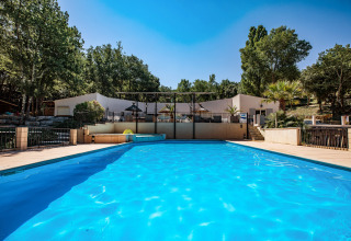 Piscina presso Slow Village Provence Occitane, circondata da alberi, giornata di sole in Occitania.