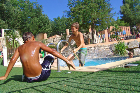 Twee jongens amuseren zich bij het zwembad in Slow Village Provence Occitane in Occitanië, Frankrijk.