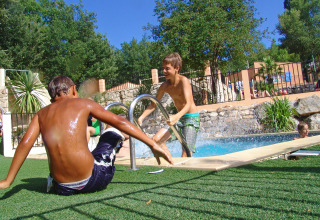 Twee jongens amuseren zich bij het zwembad in Slow Village Provence Occitane in Occitanië, Frankrijk.