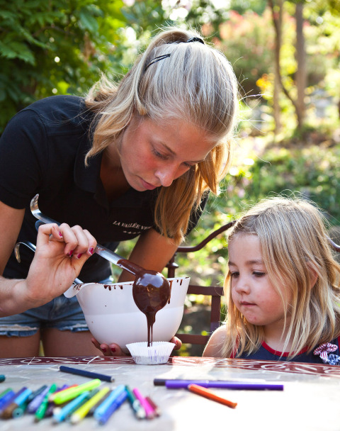 Een vrouw en een kind maken buiten chocoladesnoepjes in Slow Village Provence Occitane, Occitanië, Frankrijk.