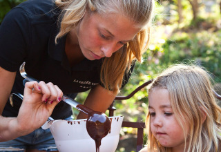Een vrouw en een kind maken buiten chocoladesnoepjes in Slow Village Provence Occitane, Occitanië, Frankrijk.