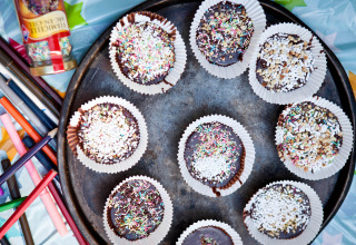 Chocoladecupcakes met kleurrijke hagelslag in papiervormpjes op schaal, Slow Village Provence Occitane.