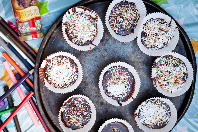Chocolate cupcakes with colorful sprinkles in paper liners on a tray, Slow Village Provence Occitane.