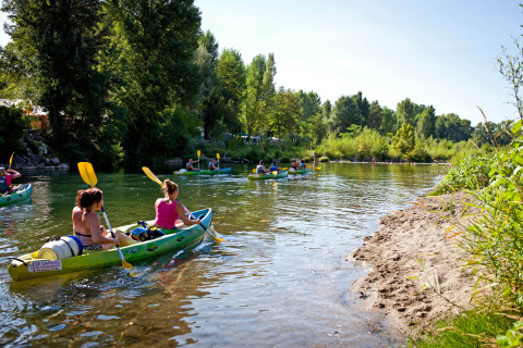 Mensen peddelen in kajaks op een rivier bij Slow Village Provence Occitane, omringd door natuur.