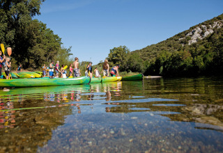 Bezoekers bij Slow Village Provence Occitane peddelen met kano’s op een zonnige rivier in Occitanië, Frankrijk.