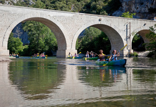 Persone fanno kayak sotto un antico ponte di pietra a Slow Village Provence Occitane, Occitania, Francia.