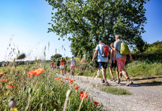 Groep mensen wandelt op bloemenrijk pad bij Slow Village Provence Occitane in de Franse Occitanië.