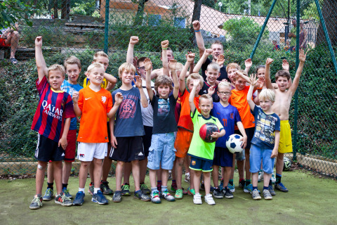 Blije groep kinderen op een speelveld in Slow Village Provence Occitane vakantiepark, Occitanië, Frankrijk.