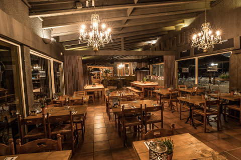 Gezellig restaurant met houten tafels en kroonluchters in Slow Village Provence Occitane, Occitanië, Frankrijk.