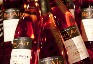 Bottles of Domaine de Bel Air rosé wine from Côtes du Rhône displayed at Slow Village Provence Occitane, France.